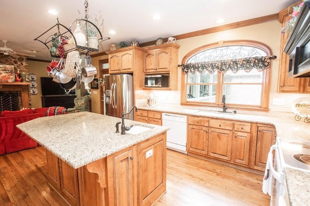1145 Thurston Snow Rd, Good Hope, GA 30641 - kitchen with stainless steel appliances, crown molding, a center island with sink, light stone countertops, and light wood-style flooring