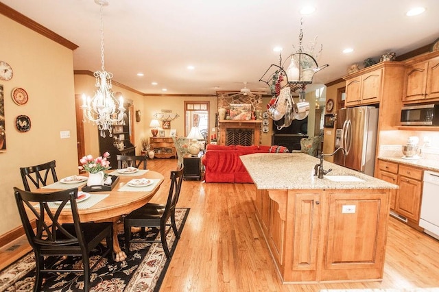1145 Thurston Snow Rd, Good Hope, GA 30641 - kitchen featuring appliances with stainless steel finishes, ornamental molding, a kitchen island with sink, a chandelier, and light stone counters
