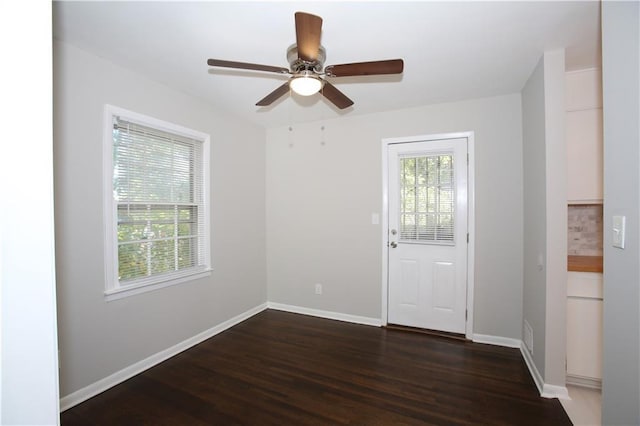 spare room with baseboards, plenty of natural light, wood finished floors, and a ceiling fan