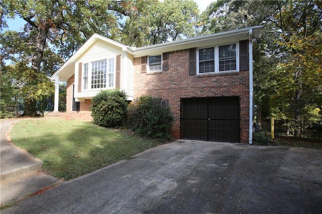 view of front of property with driveway, a garage, a front yard, and brick siding