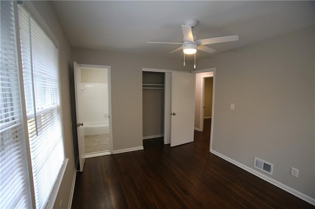 unfurnished bedroom with visible vents, ceiling fan, baseboards, dark wood finished floors, and a closet