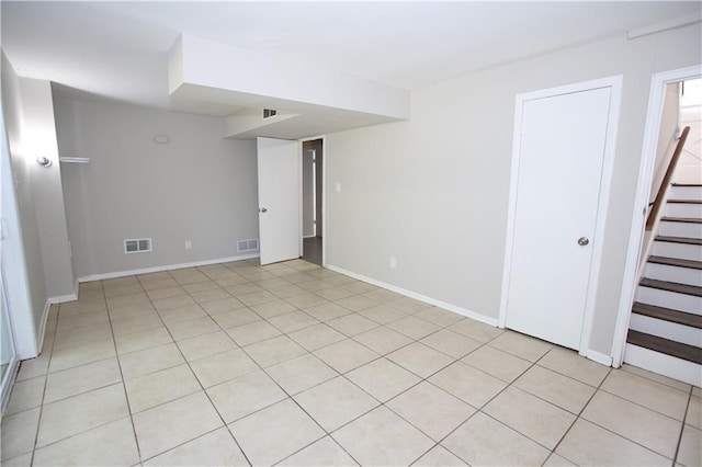 empty room featuring stairway, baseboards, and visible vents