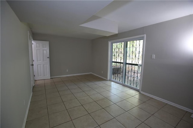 unfurnished room featuring light tile patterned flooring and baseboards