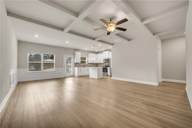 unfurnished living room with beamed ceiling, ceiling fan, coffered ceiling, and light hardwood / wood-style floors