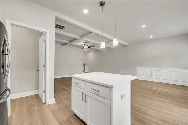 kitchen featuring hanging light fixtures, coffered ceiling, white cabinets, beamed ceiling, and light wood-type flooring