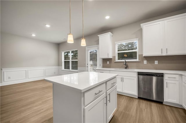 kitchen featuring white cabinets, decorative light fixtures, sink, and dishwasher