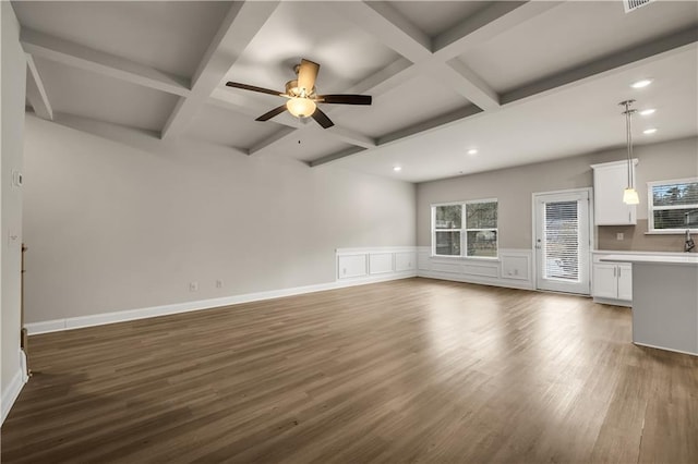 unfurnished living room featuring beamed ceiling, coffered ceiling, and dark hardwood / wood-style flooring