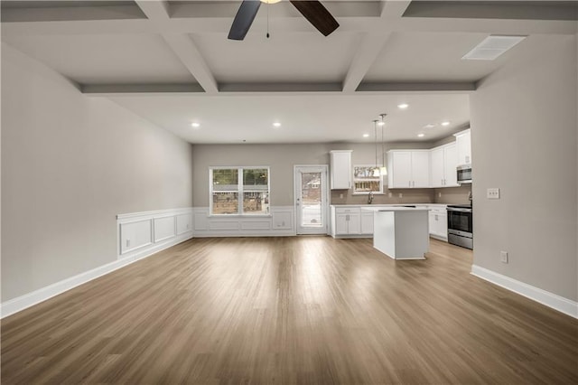 kitchen with stainless steel appliances, white cabinets, light hardwood / wood-style floors, and decorative light fixtures