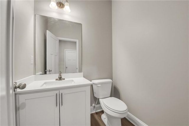 bathroom featuring vanity, toilet, hardwood / wood-style floors, and a notable chandelier