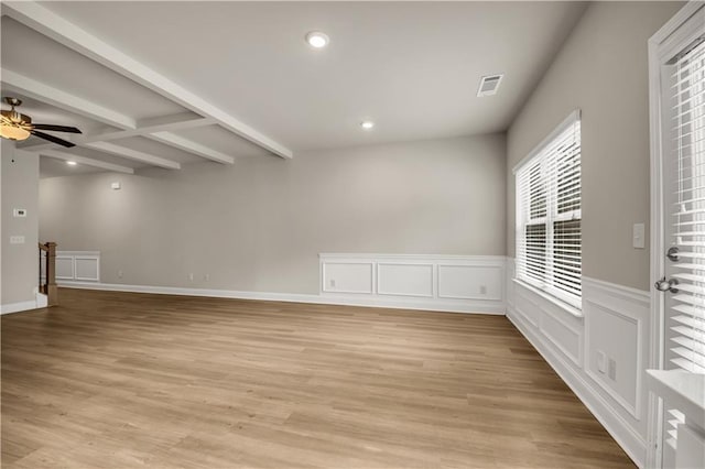 unfurnished room featuring coffered ceiling, ceiling fan, beamed ceiling, and light wood-type flooring