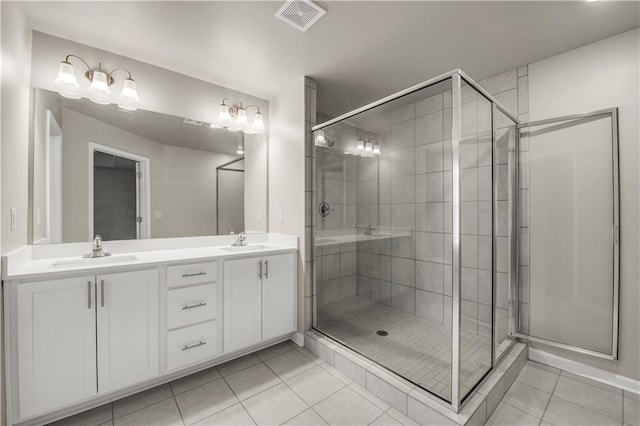 bathroom featuring vanity, a shower with door, and tile patterned flooring