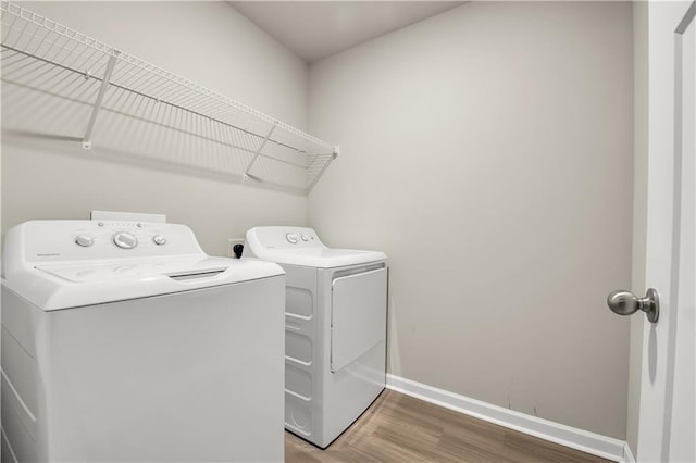 clothes washing area with wood-type flooring and separate washer and dryer