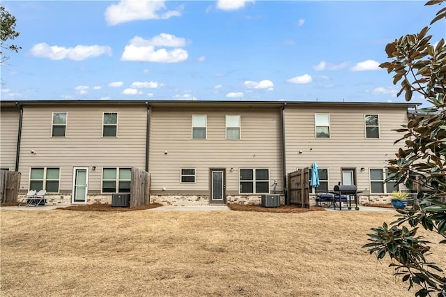 back of house featuring central AC unit and a yard