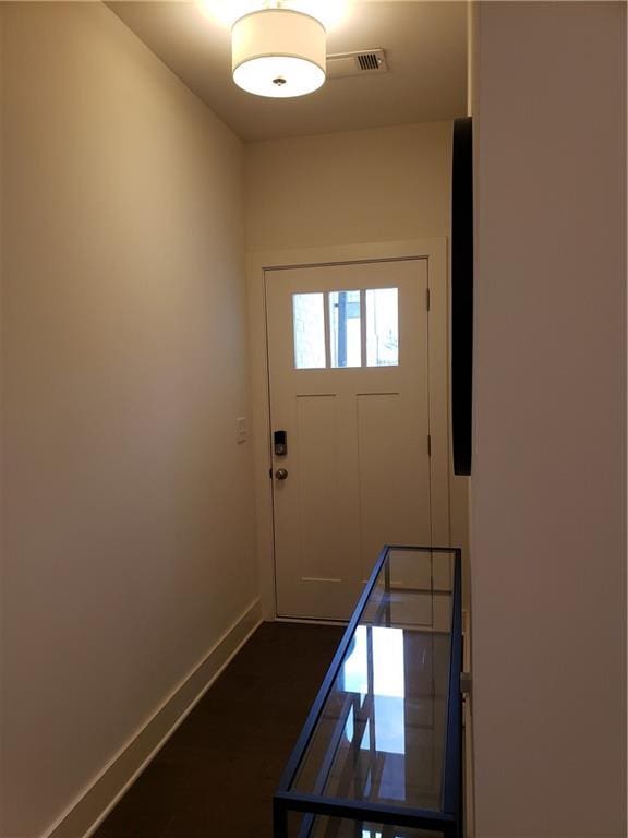 entryway featuring visible vents, baseboards, and dark wood-style flooring