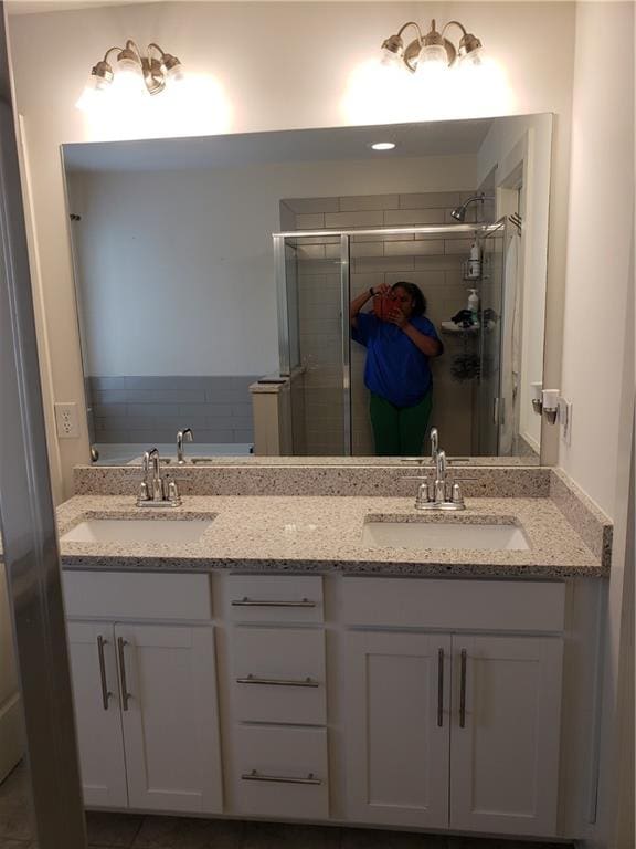 bathroom featuring double vanity and a shower with shower door