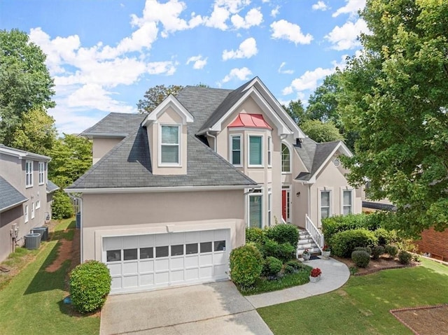 view of front of property with cooling unit, a front yard, and a garage