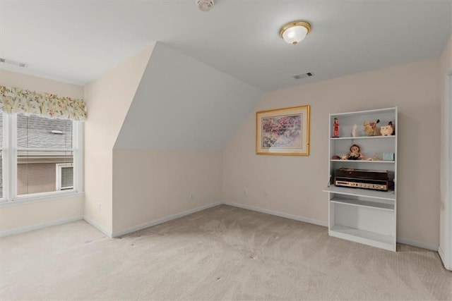 bonus room with vaulted ceiling and light carpet