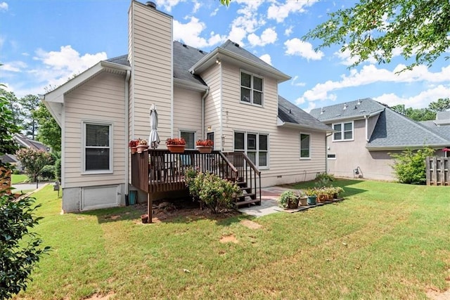 rear view of house with a deck and a lawn