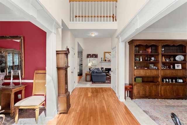 hall featuring light wood-type flooring and crown molding