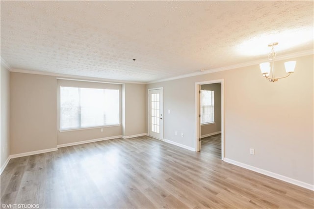 spare room featuring ornamental molding, a notable chandelier, a textured ceiling, and light hardwood / wood-style flooring