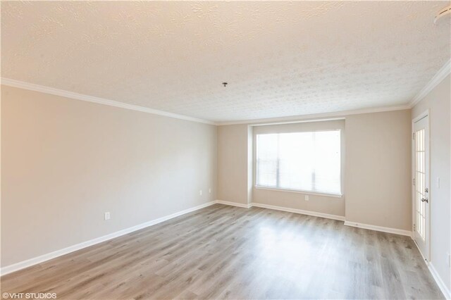 spare room featuring ornamental molding, light hardwood / wood-style flooring, and a textured ceiling