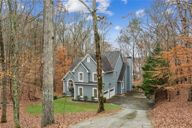 traditional-style home featuring driveway, roof with shingles, stucco siding, an attached garage, and a front lawn