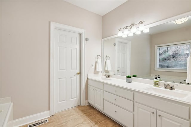 full bath featuring a sink, visible vents, a bath, and double vanity