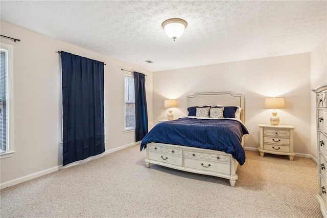 carpeted bedroom with visible vents, a textured ceiling, and baseboards