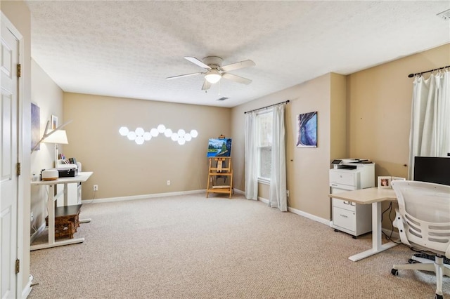 carpeted office with baseboards, a textured ceiling, and a ceiling fan