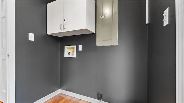 laundry room featuring light wood finished floors, hookup for a washing machine, cabinet space, and baseboards