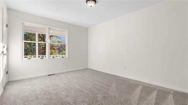 carpeted empty room with visible vents and baseboards