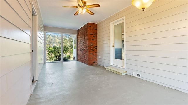 empty room with ceiling fan, wooden walls, visible vents, and finished concrete floors