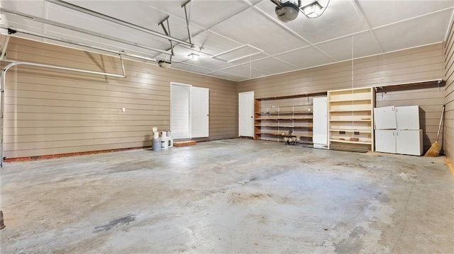 garage with wood walls and a garage door opener