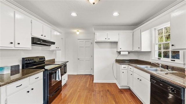 kitchen featuring under cabinet range hood, a sink, white cabinetry, ornamental molding, and black appliances