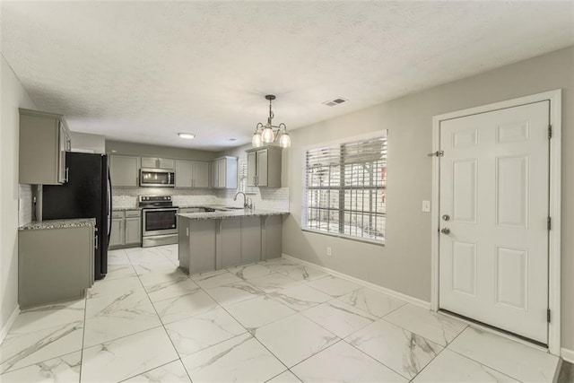 kitchen featuring stainless steel appliances, gray cabinetry, kitchen peninsula, and decorative light fixtures