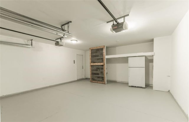 garage featuring white refrigerator and a garage door opener