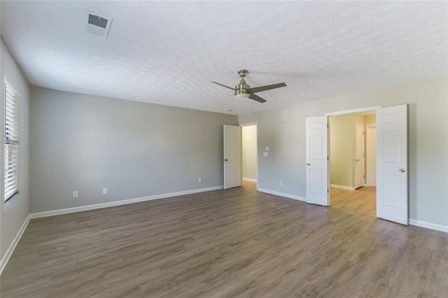 empty room featuring ceiling fan, dark hardwood / wood-style floors, and a textured ceiling