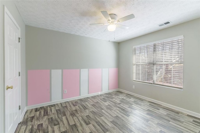 unfurnished room with hardwood / wood-style flooring, ceiling fan, and a textured ceiling