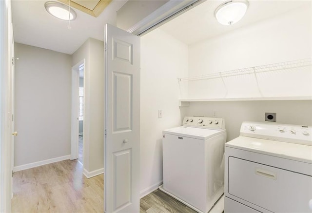 clothes washing area with light hardwood / wood-style floors and washing machine and dryer