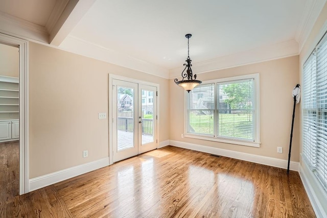 unfurnished dining area with crown molding, french doors, and wood finished floors