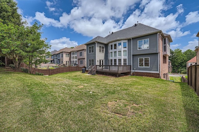 back of property featuring a yard, a deck, and fence