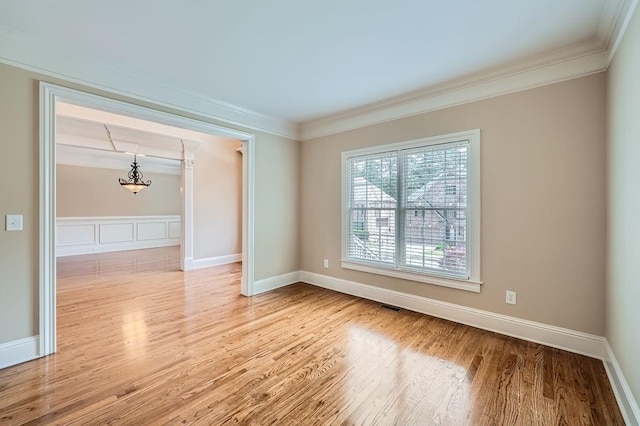 spare room featuring ornamental molding and light wood-style flooring