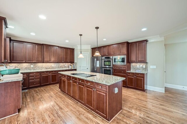 kitchen featuring crown molding, a center island, tasteful backsplash, light wood finished floors, and stainless steel appliances