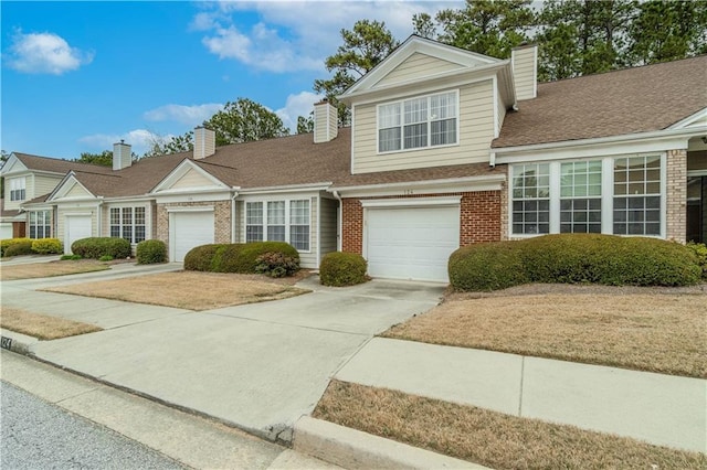 124 Camry Ln, Grayson, GA 30017 - view of front of home featuring brick siding, a chimney, driveway, and roof with shingles