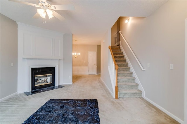 124 Camry Ln, Grayson, GA 30017 - unfurnished living room featuring light colored carpet, a ceiling fan, stairway, a fireplace with flush hearth, and a chandelier