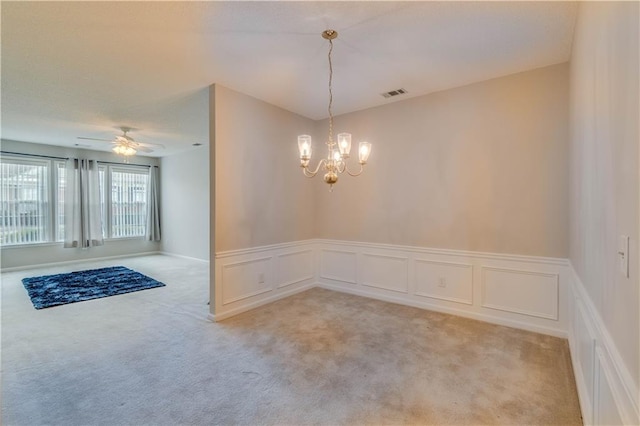 124 Camry Ln, Grayson, GA 30017 - unfurnished dining area featuring light carpet, a chandelier, a decorative wall, a ceiling fan, and a wainscoted wall