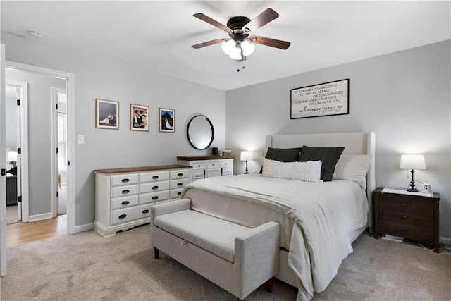 bedroom with light colored carpet, baseboards, and ceiling fan