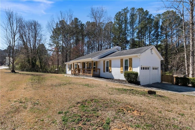 single story home featuring an attached garage, a front yard, a porch, and driveway