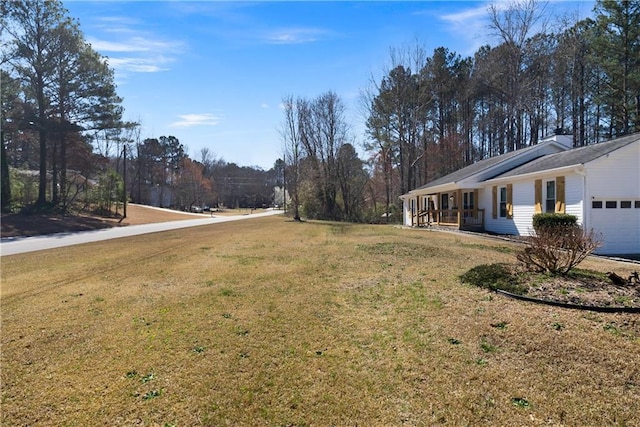 view of yard with a porch and an attached garage