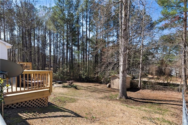 view of yard featuring a storage shed, an outbuilding, and a wooden deck